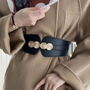 Close-up of black PU leather waist belt with three textured gold metal buckles on a model