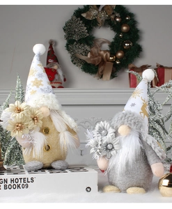 Close-up of gold and silver Christmas gnomes with glitter hats on festive background