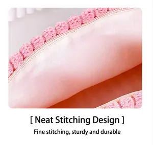 Detailed view of pink makeup bag interior featuring smooth zipper and pom-pom trim