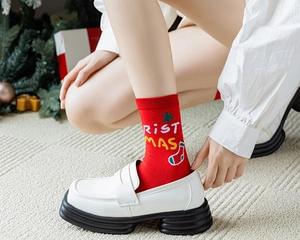 Gros plan de chaussettes de Noël rouges avec mocassins sur un fond de fête décoré