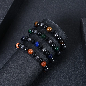 Détail de quatre bracelets de protection en œil de tigre et pierre noire de 8 mm sur socle