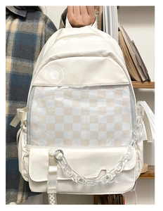 Detail of cream backpack featuring a transparent PVC window and beige checkerboard lining