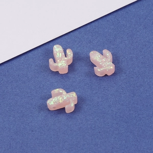 Macro view of pink synthetic opal cactus beads with colorful glitter and small holes