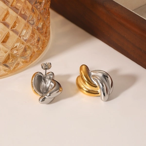 Two-tone gold and silver twisted knot stainless steel stud earrings on a stylist display