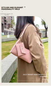 Pink crescent underarm bag with woven texture and matching coin purse on a model