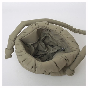 Detailed interior of khaki quilted puffer bag with secure silver zipper pocket