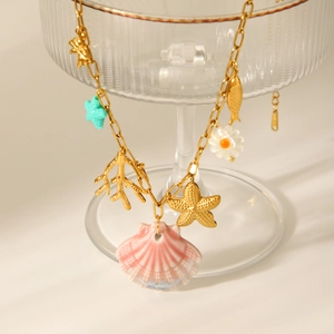 Detail of starfish and pink shell charms on a gold stainless steel chain necklace