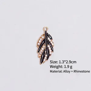 Detail of leaf-shaped alloy pendant with black enamel oil and sparkling rhinestones