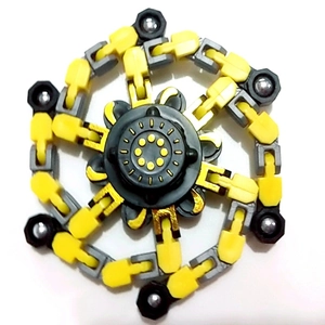Close-up of a mechanical chain fidget spinner with yellow and gray links and metal balls
