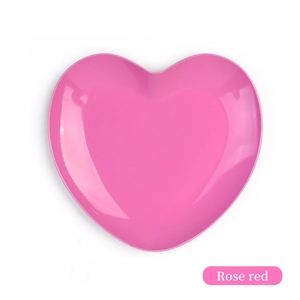 Top view of a rose red heart-shaped metal tray for jewelry storage on white background