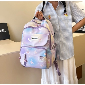 Detail view of purple gradient school backpack featuring butterfly and moon print patterns