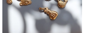 Detailed close-up of 18K gold plated charms featuring money bag, leopard head, and fish shapes