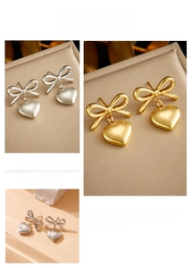 Détail de boucles d'oreilles nœud et cœur en or et argent avec texture lisse polie