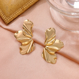 Vintage matte gold irregular flower petal stud earrings on soft silk background