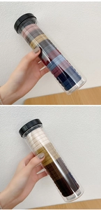 Close-up of assorted high-elastic seamless hair ties stored in a clear cylindrical jar