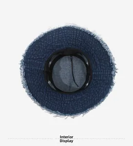 Detail of blue denim bucket hat interior with adjustable drawstring and frayed edge