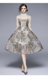 Nahaufnahme von Champagnergold-Jacquard-Kleid mit Netzhülsen und floralen Stickereidetails