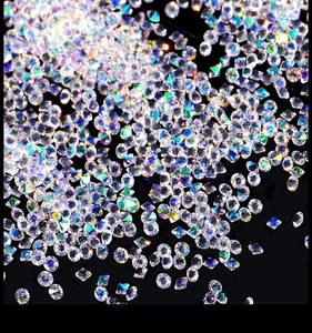 Close-up of sparkling iridescent nail art micro beads scattered on black surface