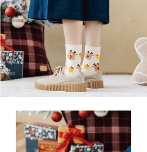 Detail of white Christmas sock with cartoon reindeer and yellow bell knit patterns
