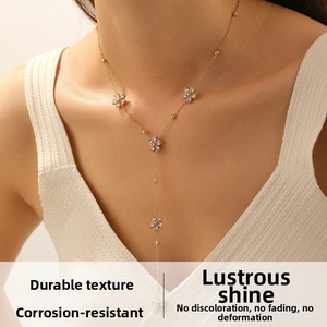 Détail du collier floral doré en Y avec cristaux brillants et chaîne pendante