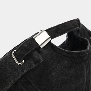 Détail de la boucle en métal argenté et de la sangle en tissu lavé sur le bonnet