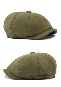 Vista detallada de la gorra de ante verde militar con un botón metálico de estilo retro