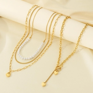 Details einer mehrlagigen goldenen Edelstahlkette mit Barockperlen und Herzanhängern