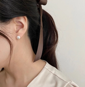 Close-up of 8mm white pearl earring on model for a minimalist Korean jewelry style