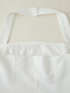 Detail der weißen Neckholder-Kleid-Rückseite mit Knöpfen und vertikalen Steppnähten