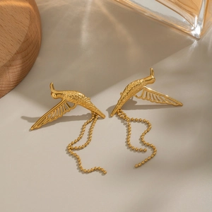 Boucles d'oreilles colibri dorées minimalistes avec chaînes à billes sur fond neutre