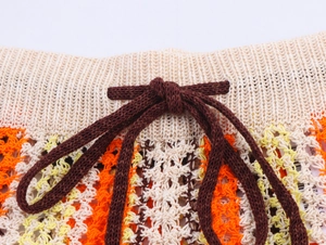 Gros plan détaillé de la taille à cordon avec motifs crochetés ondulés orange et jaune