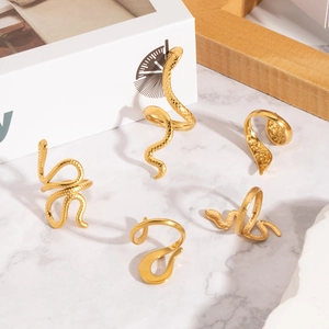 Detailed view of gold snake-shaped stainless steel rings with textured scales on marble