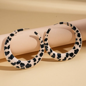 Macro shot of large leopard print C-shape resin hoop earrings with silver pins
