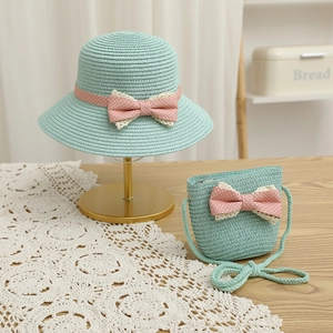 Detail of mint green straw hat and mini bag set with pink polka dot bow decoration