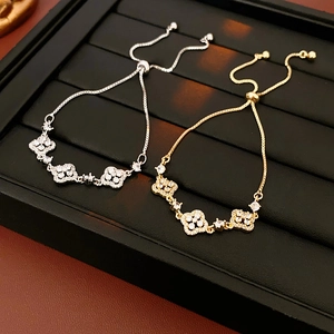 Detail of clover zircon bracelets in gold and silver finish on leather display