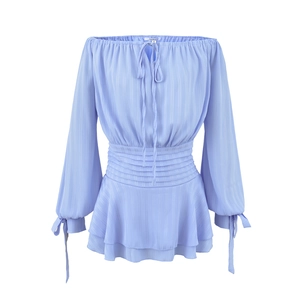 Détail de robe en mousseline lilas à épaules dénudées avec plis et ourlet volanté