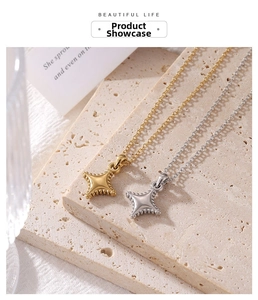 Detailed view of gold and silver mini star pendants on cross chains over travertine
