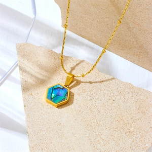 Minimalist gold hexagon abalone shell pendant necklace on a natural stone surface