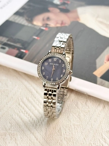 Close-up of women's quartz watch featuring a crystal bezel and silver metal band