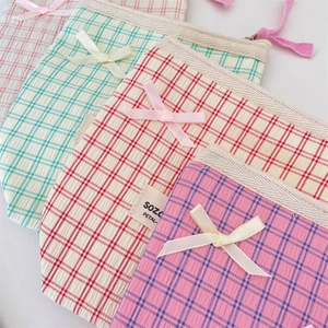 Detail of checkered makeup bag with ribbon bow and secure zipper closure