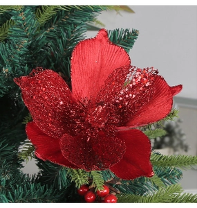 Detailed close-up of red glitter Christmas flower with mesh petals on Xmas tree branch