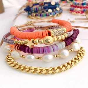 Close-up of Bohemian stacked bracelets with freshwater pearls and colorful beads