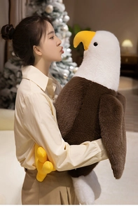 Large plush bald eagle toy held by model, showing realistic details and fluffy soft texture