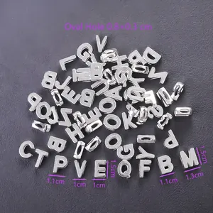 Close-up of polished silver metal alphabet beads with oval holes for DIY jewelry making
