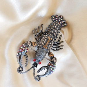 Detail of lobster brooch featuring champagne rhinestones on gunmetal finish base