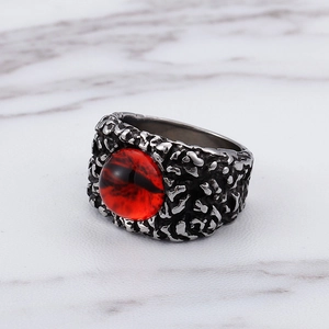 Macro shot of gothic ring featuring red demon eye stone and retro silver metal band