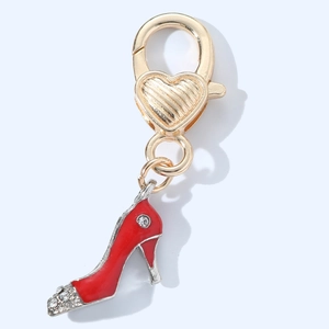 Detail of red high heel keychain charm with crystals and golden heart-shaped clasp