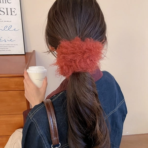 Close-up of fluffy red faux fur scrunchie worn on a ponytail for autumn fashion