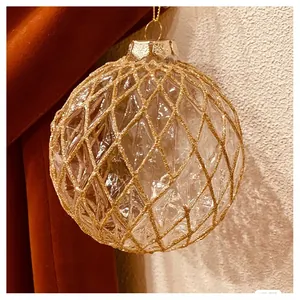 Detail of champagne glass Christmas ball with gold glitter diamond grid patterns