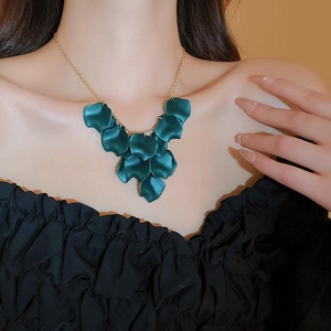 Elegant gold necklace with matte dark green petal pendants shown on a model neck